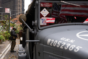 A young boy puts on a collection of military gear before the 106th annual Veterans Day Parade.