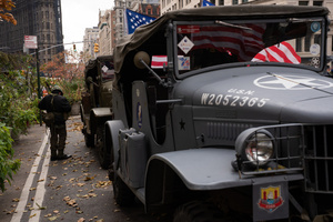 A young boy puts on a collection of military gear before the 106th annual Veterans Day Parade.