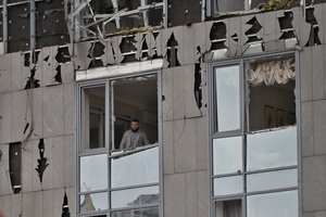 A man seen in the window of an apartment building damaged by a Russian strike.