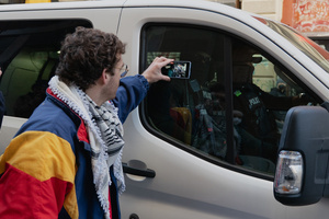 A protestor records Immigration and Customs Enforcement (ICE) agents inside their van before an attempted sweep on Canal Street in Manhattan. ICE has cracked down on vendors selling counterfit goods in New York City.