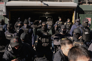 Immigration and Customs Enforcement (ICE) agents clear the entrance of the parking garage they rallied at before an attempted sweep on Canal Street in Manhattan. ICE has cracked down on vendors selling counterfit goods in New York City.