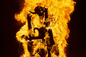 The fire consumes the paper figure known as "The Three Wise Devils" during the Burning of the Devil on the eve of the celebration of the Virgin of the Immaculate Conception, festivities that mark the beginning of Christmas in Guatemala.