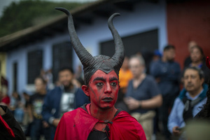 A man dressed as a devil seen during the Burning of the Devil on the eve of the celebration of the Virgin of the Immaculate Conception, festivities that mark the beginning of Christmas in Guatemala.