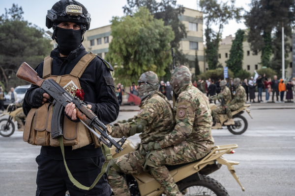 Armed security personnel on the streets as Syrian transitional government stages a military parade at Umayyad Square as part of the Liberation Day anniversary. Syrians crowd the streets of central Damascus, waving flags and singing patriotic songs amid fireworks, flares, and car horns as they celebrate the first anniversary of the fall of the Assad regime.