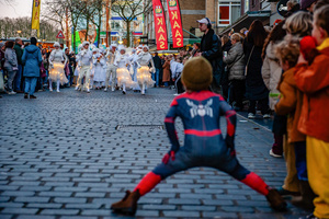 A boy in a Spiderman costume is seen watching the parade approaching. The Winter Wonder Parade marks the festive opening of the annual Nijmegen Winter Weeks. This enchanting spectacle features a fairytale procession including a winter carriage pulled by white horses, ice queens on stilts, musicians, dancers, and jugglers. The parade departs from the Lindenberg at 4:30 PM and concludes at the Grote Markt, where the Christmas tree lighting officially starts three weeks of winter magic.