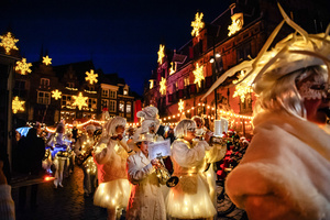 The music band is seen leaving the square under the Christmas lights. The Winter Wonder Parade marks the festive opening of the annual Nijmegen Winter Weeks. This enchanting spectacle features a fairytale procession including a winter carriage pulled by white horses, ice queens on stilts, musicians, dancers, and jugglers. The parade departs from the Lindenberg at 4:30 PM and concludes at the Grote Markt, where the Christmas tree lighting officially starts three weeks of winter magic.