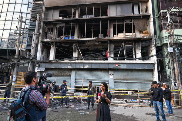 Media personnel covering the aftermath of the incident in front of the Prothom Alo building, after it was attacked, vandalized, and set ablaze. Violence broke out in Dhaka following the death of youth leader Sharif Osman Hadi, a key figure in Bangladesh’s 2024 pro-democracy uprising, who died in Singapore from injuries sustained in an assassination attempt. As news of his death spread, protesters attacked, vandalized, and set fire to several buildings, including the offices of leading national dailies Prothom Alo and The Daily Star, as well as the cultural institution Chhayanaut. Windows were smashed, fires burned inside and outside media offices, staff were trapped inside, and the scale of destruction became clear in daylight—intensifying concerns over public safety and press freedom.