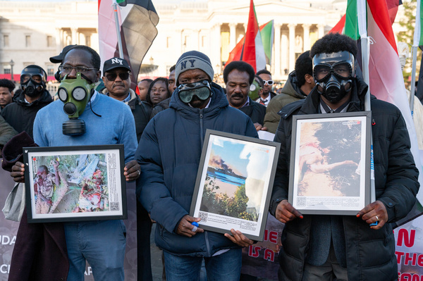 Men wearing gas masks hold photos during the rally. Sudanese protesters gathered in Trafalgar Square to condemn the use of chemical weapons by the Sudanese Armed Forces, calling for international accountability and protection for civilians.