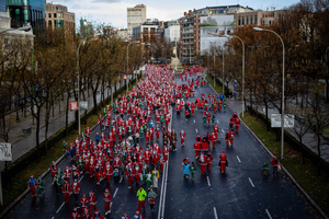 Hundreds of people run through the center of Madrid during a charity race. A charity race was organized by the Spanish department store chain El Corte Ingles where participants, mostly families, run dressed as Santa Claus or in Christmas-themed costumes.