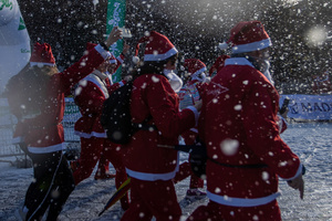 A group of participants in a charity race reach the finish line. A charity race was organized by the Spanish department store chain El Corte Ingles where participants, mostly families, run dressed as Santa Claus or in Christmas-themed costumes.