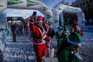 A group of participants in a charity race reach the finish line. A charity race was organized by the Spanish department store chain El Corte Ingles where participants, mostly families, run dressed as Santa Claus or in Christmas-themed costumes.
