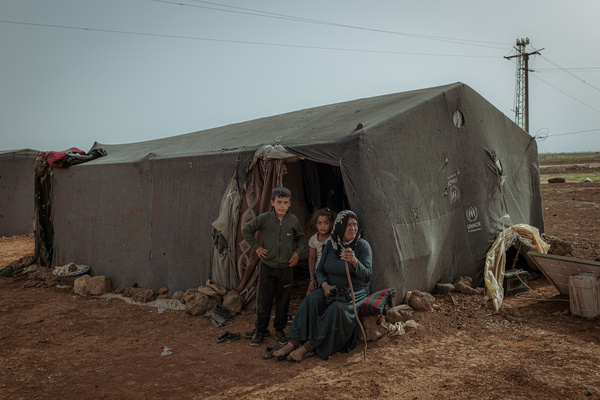 Mariam Hallil from the Al-Hasakah area with her children in an improvised refugee camp near Da'el. Devastating convergence of climate crisis and war's aftermath in Daraa province. Once known as southern Syria's breadbasket with fertile lands sustained by advanced irrigation systems, the region now faces its worst drought in over 25 years, with reservoir levels plummeting from 33 million to just 3 million cubic meters. The 13-year civil war destroyed crucial water infrastructure and turned water access into a weapon of warfare, while desperate farmers drilled tens of thousands of random wells that accelerated groundwater depletion. Israel's December 2024 occupation of the strategic Al-Mantara Dam following Assad's fall has further complicated the crisis, threatening the region's remaining water security. With the Yarmouk River completely dried, crops withering, livestock dying, and no prospects for improvement, Daraa's farmers who fought for over a decade for their land increasingly see emigration as their only future.