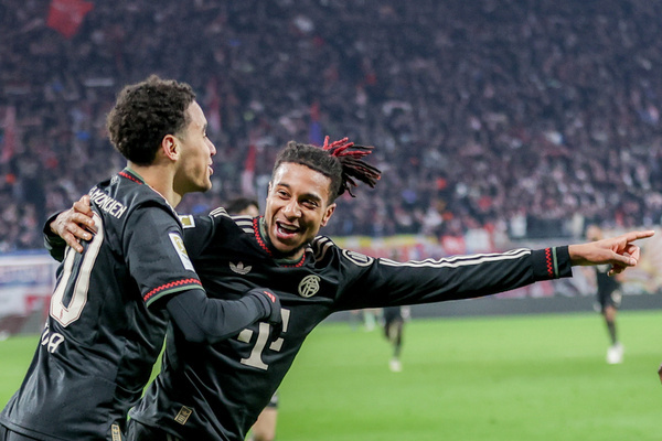 Jamal Musiala of Bayern Munich (L) and Michael Olise of Bayern Munich (R) celebrate after scoring a goal during the Bundesliga match between RB Leipzig and Bayern Munich at Red Bull Arena. FInal Score; RB Leipzig 1:5 Bayern Munich.