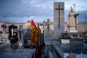 A member of the Endiablada brotherhood prays beside a relative's grave in the town cemetery, during the festival of La Endiablada in Almonacid del Marquesado. Celebrated in honor of the Virgin of Candelaria and Saint Blaise of Sebaste, La Endiablada is considered one of Spain’s oldest traditional festivals. During the event, men known as “the Devils,” dressed in colorful costumes with cowbells around their waists, jump and dance through the streets while carrying the statue of the saint in a lively procession.