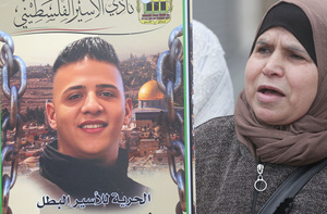 A mother of a Palestinian prisoner chants slogans while holding a picture of her son during the solidarity vigil in front of the International Committee of the Red Cross in Nablus, West Bank. The vigil also served as a protest against the death penalty law approved by the Israeli cabinet.