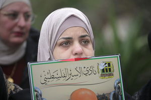 A mother of a Palestinian prisoner shed tears during the solidarity vigil in front of the International Committee of the Red Cross in Nablus, West Bank. The vigil also served as a protest against the death penalty law approved by the Israeli cabinet.