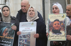 Mothers of Palestinian prisoners seen holding up pictures of their sons during the solidarity vigil in front of the International Committee of the Red Cross in Nablus, West Bank. The vigil also served as a protest against the death penalty law approved by the Israeli cabinet.