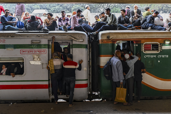 Bangladeshi people leave Dhaka city and travel on the roof of a train at Kamlapur Railway Station as they head to their hometowns to cast their votes ahead of the Bangladesh Parliament election.