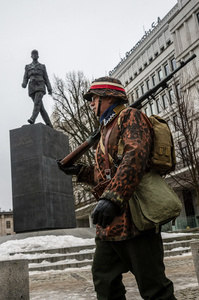 A historical reenactor marches in front of a statue of French General Charles de Gaulle. On the afternoon of the 14th of February, Poland celebrates the National Day of Remembrance of the Home Army Soldiers, a state holiday commemorating the Polish underground militias during World War II. After a Mass for the fallen at the Basilica of the Holy Cross, a Parade of Respect passes through the streets of Warsaw in the direction of the Monument to the Polish Underground State and the Home Army at the Polish Parliament, where a wreath-laying ceremony takes place.