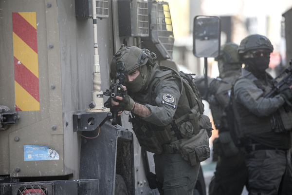 Israeli soldiers point their weapons at Palestinian civilians during a security operation in the Askar refugee camp. Israeli forces raided and searched Palestinian shops as part of a broader “search and arrest” campaign in Nablus, including the Ras al-Ain area, the Old City, and the Askar refugee camp. In Askar, soldiers used live ammunition and stun grenades during the operation, injuring at least two teenagers. Three young men were detained in the camp, according to the military, as part of efforts to dismantle local infrastructure.