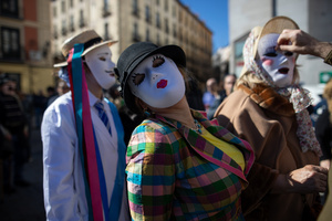 People wearing white masks as part of the performance attend the 1st Madrid Masquerade Parade. during the 1st Masquerade Parade through the center of Madrid, organized by the regional associations of Asturias, Galicia, and Zamora, the heart of the Spanish capital was transformed into a stage for ancestral rites from the Spanish regions of Asturias, Galicia, and Zamora.