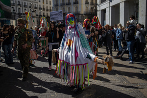 A woman in a colorful costume and mask is seen. during the 1st Masquerade Parade through the center of Madrid, organized by the regional associations of Asturias, Galicia, and Zamora, the heart of the Spanish capital was transformed into a stage for ancestral rites from the Spanish regions of Asturias, Galicia, and Zamora.
