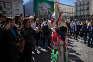 Several women photograph a performer. during the 1st Masquerade Parade through the center of Madrid, organized by the regional associations of Asturias, Galicia, and Zamora, the heart of the Spanish capital was transformed into a stage for ancestral rites from the Spanish regions of Asturias, Galicia, and Zamora.