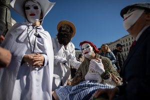 People wearing white masks as part of the performance attend the 1st Madrid Masquerade Parade. during the 1st Masquerade Parade through the center of Madrid, organized by the regional associations of Asturias, Galicia, and Zamora, the heart of the Spanish capital was transformed into a stage for ancestral rites from the Spanish regions of Asturias, Galicia, and Zamora.