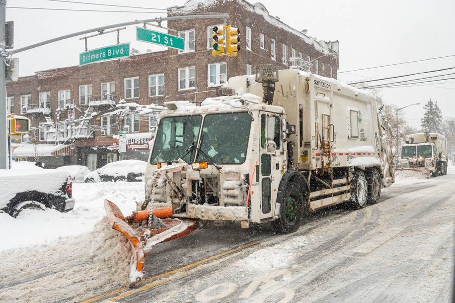 New York City Sanitation (DSNY) truck with snow plow clears snow off the street amid a nor'easter with blizzard conditions on February 23, 2026 in the Queens borough of New York City.