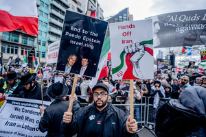 Pro-Iranian regime protestor holds aloft a placard implicating President Donald Trump was involved with Epstein in a paedophile ring. Many thousands congregated in Central London in an international demonstration of support for Palestinian rights. They were separated by Police from pro-Israeli and anti-Iranian-regime counter-protestors who met on the opposite side of the River Thames after the rally was banned from marching by the Home Secretary Shabana Mahmood. Rapper Bob Vylan spoke at the rally and is currently being investigated for chanting “Death to the IDF”.