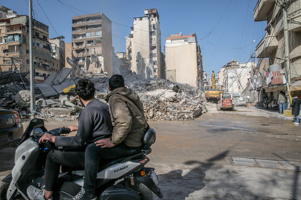 Men on a motorbike ride past the remains of a building in Bachoura, which was hit by an Israeli airstrike. At least 886 people have been killed, according to Lebanon's ministry of health, since the resumption of all-out hostilities between Israel and Hezbollah.