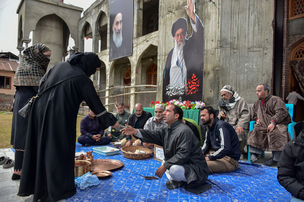 A volunteer of the Shiite Muslim community collects Indian Rupee banknotes from a woman during a donation drive in support of war-stricken Iran. As the West Asia conflict entered its fourth week, residents of Kashmir have come forward with donations of cash, gold jewelry, and copper utensils to support people affected by the war in Iran.