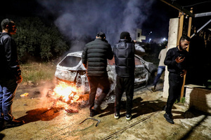 People inspect a burning car following an attack by Jewish settlers on the village of Deir al-Hatab, east of Nablus in the West Bank. Israeli settlers from Elon Moreh carried out attacks in several Palestinian villages, including Deir al-Hatab, following the funeral of 18-year-old Yehuda Sherman. Israeli police said Sherman died in a car collision with a Palestinian vehicle and are investigating whether it was deliberate or an accident. After the funeral, settlers set fire to homes and vehicles and spray-painted “revenge” in Hebrew, leaving at least 10 Palestinians injured, including one man shot and a woman treated for smoke inhalation.