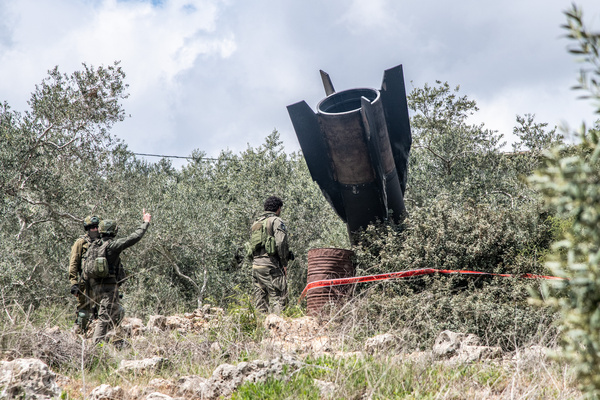Israeli Defense Forces (IDF) soldiers inspect the wreckage of an Iranian missile fragment that landed in a rural area of central Israel without causing damage.
