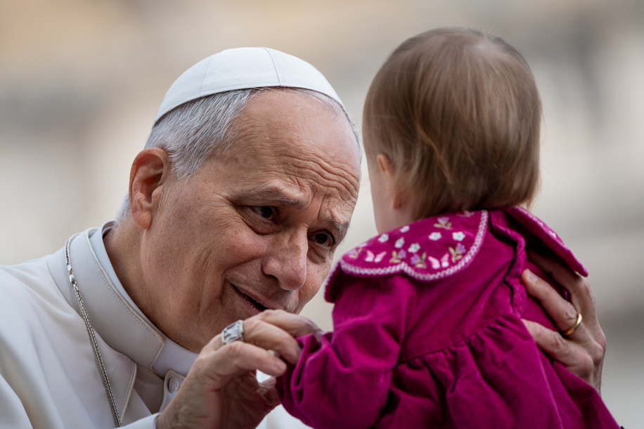 Pope Leo XIV blesses a child as he arrives to lead his traditional Wednesday General Audience in St. Peter's Square.