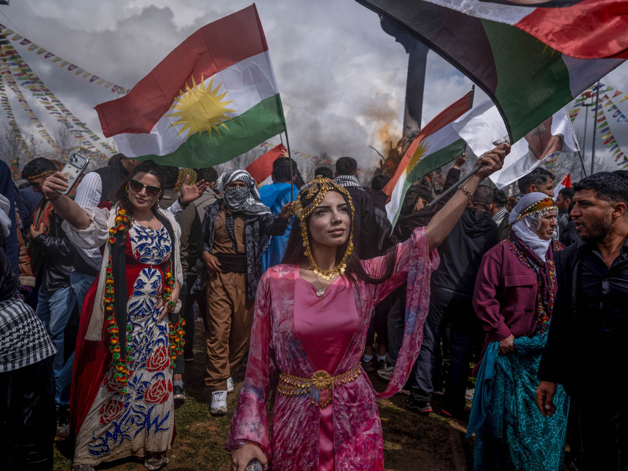 A woman in traditional clothing poses for a photo with Kurdish flag next to a Newroz fire. The final event of the Nevruz Bayram (Newroz Festival) celebrations, organized by the DEM Party in 53 different locations this year, was held at Nevruz Park in the Ba?lar district, had the slogan 
