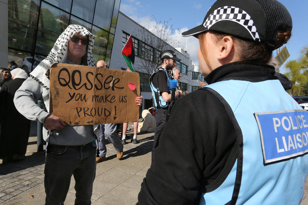 A protester holds a placard saying ‘Qesser You Make Us Proud’ as a police officer tries to hold a conversation. Protesters gathered outside Hatfield police station following the arrest of former Filton 24 prisoner and hunger striker Qesser Zuhrah. Counter terrorism police arrested her at her home for a social media post. Zuhrah was released from prison a month ago after spending 15 months on remand after being accused of breaking in and damaging weaponry at Elbit Systems Filton facilities in Bristol in August 2024.
