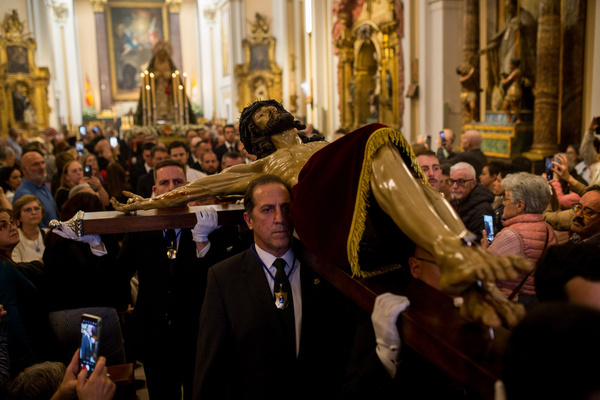 Members of the brotherhood carry the Christ figure, and behind it, the image of Our Lady of the Angels is carried on their shoulders as the procession leaves the church during the transfer of the image of Christ of the Halberdiers to the Royal Palace, for preparations for the procession that will take place through the streets of Madrid next Good Friday. Organized by the Congregation of the Holy Christ of Faith, Christ of the Halberdiers and Mary Immaculate Queen of the Angels.