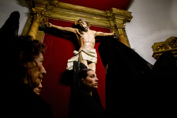 Women from the brotherhood dressed in traditional Andalusian attire stand before the crucified Christ inside the church during the procession of the Holy Christ of the Three Falls from the Royal Parish Church of Santiago and San Juan Bautista, which wound through the streets of Madrid on Holy Wednesday.
