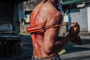 A devotee whip his back using bamboo stick while walking in the street as part of their self-flagellation on April 3, 2026 , as an act of symbolic participation in the suffering of Jesus Christ. The Catholic Church maintains that physical sacrifice is unnecessary for the forgiveness of sins, many local flagellants continue the grueling practice as a public display of faith, endurance, and communal identity.