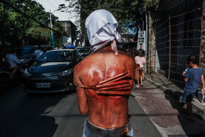 A devotee whip his back using bamboo stick while walking in the street as part of their self-flagellation on April 3, 2026 , as an act of symbolic participation in the suffering of Jesus Christ. The Catholic Church maintains that physical sacrifice is unnecessary for the forgiveness of sins, many local flagellants continue the grueling practice as a public display of faith, endurance, and communal identity.