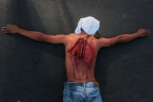 A devotee seen laying down in the street as part of self-flagellation on April 3, 2026, as an act of symbolic participation in the suffering of Jesus Christ. The Catholic Church maintains that physical sacrifice is unnecessary for the forgiveness of sins, many local flagellants continue the grueling practice as a public display of faith, endurance, and communal identity.