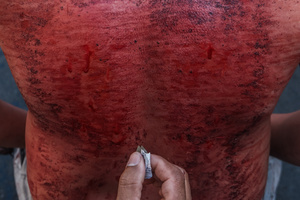 A devotee is seen receiving a cut at the back using blade as part of self-flagellation on April 3, 2026 as an act of symbolic participation in the suffering of Jesus Christ. The Catholic Church maintains that physical sacrifice is unnecessary for the forgiveness of sins, many local flagellants continue the grueling practice as a public display of faith, endurance, and communal identity.
