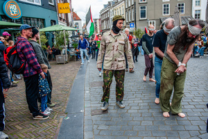 People shopping are seen watching the silent procession of pro-Palestinian activists passing by. Activists performed as the Palestinian hostages held by the Israel government during a silent procession through the city to demand their release and against Israel's new execution law. With this protest, Nijmegen for Palestine wants to draw attention to the Palestinian hostages, who are often held for months, even years, without charge in appalling Israeli detention camps.