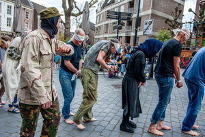 An activist dressed as an Israeli soldier is admonishing one of the Palestinian hostages. Activists performed as the Palestinian hostages held by the Israel government during a silent procession through the city to demand their release and against Israel's new execution law. With this protest, Nijmegen for Palestine wants to draw attention to the Palestinian hostages, who are often held for months, even years, without charge in appalling Israeli detention camps.