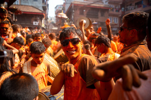 A reveler poses for a photo with vermilion powder on his face during the Festival. Sindoor Jatra or vermillion powder festival is celebrated each year to welcome the start of spring and Nepalese New Year, by playing a traditional instrument, singing, dancing, and carrying chariots of several gods and goddesses around the place.