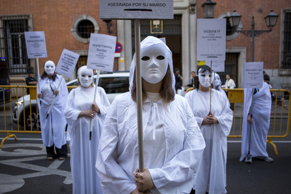 Women wearing masks and white robes hold placards during a demonstration by the Somos Ellas Madrid collective, banners bore the names of the 32 women who have been murdered in Spain so far in 2026. The feminist protest sought to raise awareness about the victims and denounce gender violence.