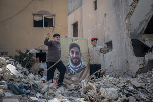 Boys stand with a picture of a Hezbollah fighter during a funeral for 15 Hezbollah fighters in the village of Qlaileh, Tyre District. Hezbollah held a mass funeral in Qlaileh, southern Lebanon, for 15 fighters and one civilian killed during the conflict with Israel. The burials took place during a 10-day ceasefire that allowed families to return to the area. Many of the deceased had been temporarily buried elsewhere due to ongoing fighting.