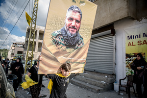 A boy holds a poster of a Hezbollah fighter during a funeral in the village of Qlaileh, Tyre District. Hezbollah held a mass funeral in Qlaileh, southern Lebanon, for 15 fighters and one civilian killed during the conflict with Israel. The burials took place during a 10-day ceasefire that allowed families to return to the area. Many of the deceased had been temporarily buried elsewhere due to ongoing fighting.