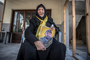 Heian Hassan, 82, holds a photo of her son, Hezbollah fighter Mehdi Hassan, during a funeral for him and 14 other fighters in the village of Qlaileh, Tyre District. Hezbollah held a mass funeral in Qlaileh, southern Lebanon, for 15 fighters and one civilian killed during the conflict with Israel. The burials took place during a 10-day ceasefire that allowed families to return to the area. Many of the deceased had been temporarily buried elsewhere due to ongoing fighting.
